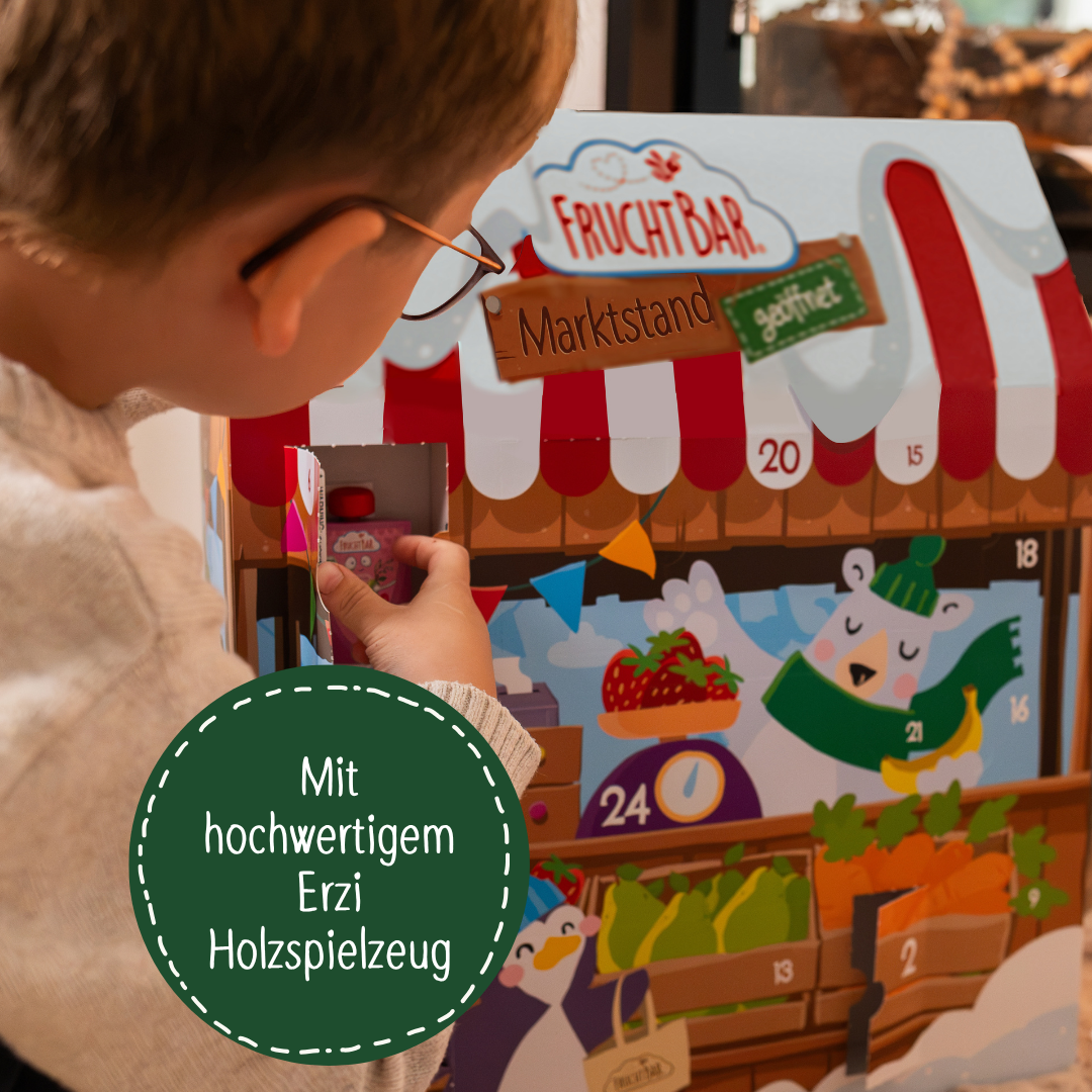 Junge spielt mit dem Adventskalender. Dunkelgrüne Bubble mit Text: Mit hochwertigem Erzi Holzspielzeug.