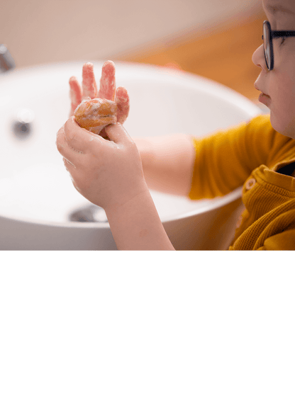 Kind mit Brille wäscht sich die Hände mit der festen Hand-Seife Pia Putzig