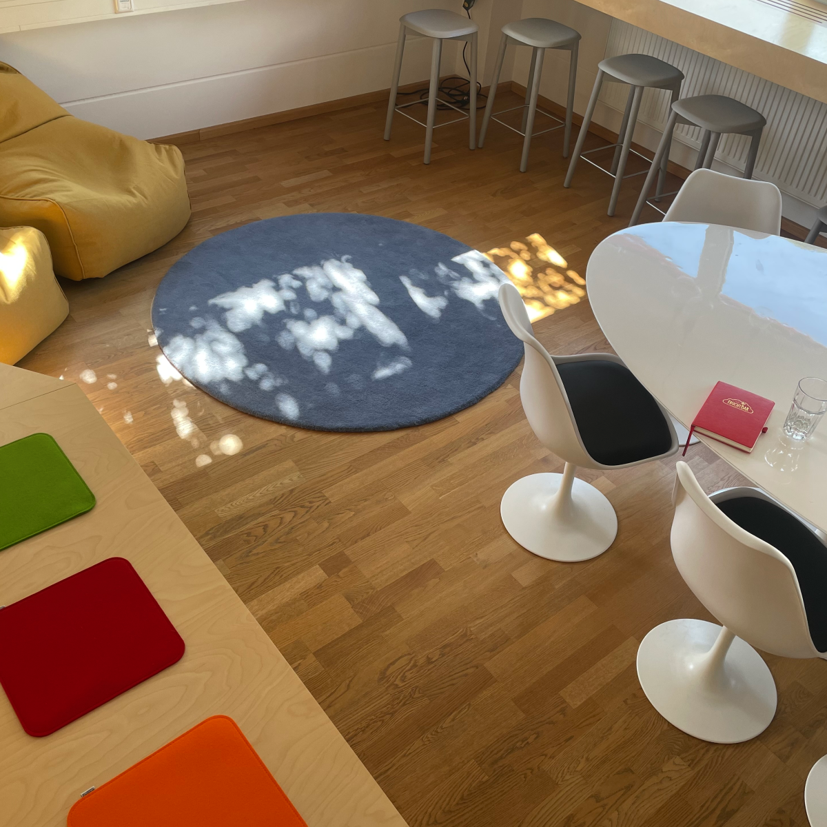 Ein Foto von einem Meetingraum, in dem ein blauer Teppich, Stühle und ein Tisch zu sehen sind. 