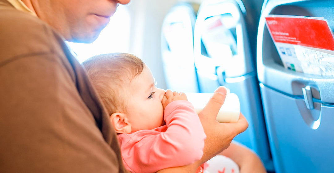 Vater gibt Baby im Flugzeug ein Fäschchen