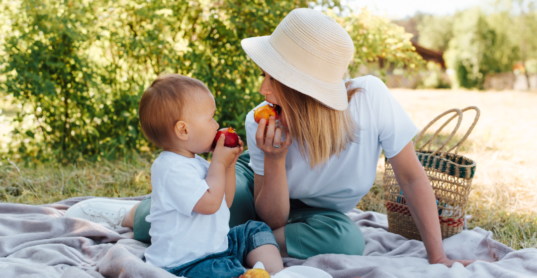 Mutter und Kind bei Sonnenschein auf Picknickdecke